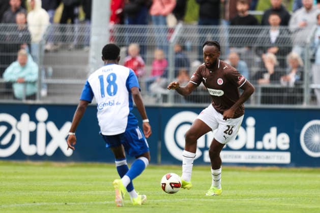 04.07.2026, Fussball, Herren, Regionalliga Nord, Testspiel, BSV Kickers Emden - FC St Pauli Ricky-Jade Jones (FC St Pauli) im Zweikampf mit Michael Igwe (blau 18 BSV Kickers Emden) *** July 4, 2026, Soccer, Men s, Regionalliga Nord, Friendly Match, BSV Kickers Emden vs. FC St. Pauli, Ricky Jade Jones of FC St. Pauli in a tackle with Michael Igwe (No. 18, BSV Kickers Emden)