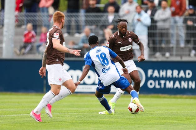 04.07.2026, Fussball, Herren, Regionalliga Nord, Testspiel, BSV Kickers Emden - FC St Pauli Ricky-Jade Jones (FC St Pauli) im Zweikampf mit Michael Igwe (blau 18 BSV Kickers Emden) *** July 4, 2026, Soccer, Men s, Regionalliga Nord, Friendly Match, BSV Kickers Emden vs. FC St. Pauli, Ricky Jade Jones of FC St. Pauli in a tackle with Michael Igwe (No. 18, BSV Kickers Emden)