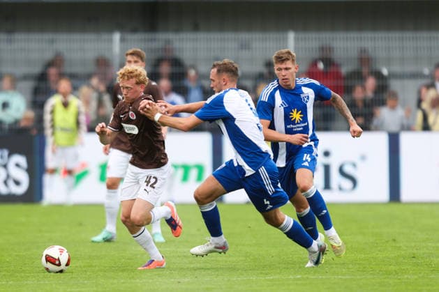 04.07.2026, Fussball, Herren, Regionalliga Nord, Testspiel, BSV Kickers Emden - FC St Pauli Marwin Schmitz (FC St Pauli) im Zweikampf mit Fabian Herbst (blau 4 BSV Kickers Emden) *** July 4, 2026, Soccer, Men s, Regionalliga Nord, Friendly Match, BSV Kickers Emden vs. FC St. Pauli, Marwin Schmitz (FC St. Pauli) in a tackle with Fabian Herbst (blue jersey 4, BSV Kickers Emden)