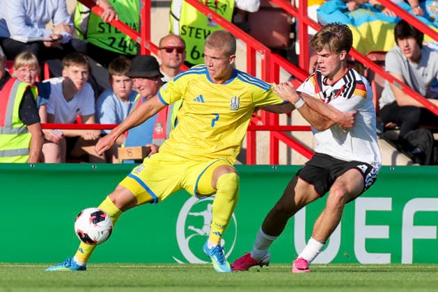 Dmytro Bohdanov (Ukraine) und Mick Schmetgens (Germany) kaempfen um den Ball, UEFA European Under-19 Championship 2026 Semi-final, Ukraine v Germany, Racecourse Ground am 08. July 2026 in Wrexham, Vereinigtes Königreich. (Foto von Marco Steinbrenner DeFodi Images) Dmytro Bohdanov (Ukraine) und Mick Schmetgens (Germany) battle for the ball, UEFA European Under-19 Championship 2026 Semi-final, Ukraine v Germany, Racecourse Ground, July 8, 2026 in Wrexham, United Kingdom. (Photo by Marco Steinbrenner DeFodi Images) - *** Dmytro Bohdanov (Ukraine) and Mick Schmetgens (Germany) battle for the ball, 2026 UEFA European Under-19 Championship Semifinal, Ukraine vs. Germany, Racecourse Ground on July 8, 2026, in Wrexham, United Kingdom. Photo by Marco Steinbrenner, DeFodi Images. Dmytro Bohdanov of Ukraine and Mick Schmetgens of Germany battle for the ball, 2026 UEFA European Under-19 Championship Semifinal, Ukraine vs. Germany, Racecourse Ground, July 8, 2026, in Wrexham, United Kingdom. Photo by Marco Steinbrenner, DeFodi Images