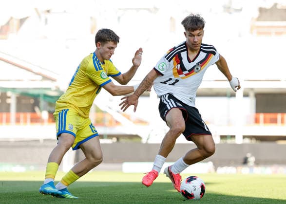 Wrexham, Wales, 8th July 2026. Moritz Reimers of Germany holds off a challenge from Vitaliy Hlyut of Ukraine during the Ukraine U19 vs Germany U19 UEFA European U19 Championship match at The Racecourse, Wrexham. Picture credit should read: Cody Froggatt Sportimage EDITORIAL USE ONLY. No use with unauthorised audio, video, data, fixture lists, club league logos or live services. Online in-match use limited to 120 images, no video emulation. No use in betting, games or single club league player publications. SPI_015_CF_UKRAINE_U19_V_GERMANY_U19 SPI-4857-0014