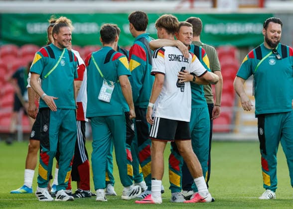 Wrexham, Wales, 8th July 2026. Christian Worns head coach of Germany embraces Mick Schmetgens of Germany as they celebrate qualifying for the the UEFA European U19 Championship final following the Ukraine U19 vs Germany U19 UEFA European U19 Championship match at The Racecourse, Wrexham. Picture credit should read: Cody Froggatt Sportimage EDITORIAL USE ONLY. No use with unauthorised audio, video, data, fixture lists, club league logos or live services. Online in-match use limited to 120 images, no video emulation. No use in betting, games or single club league player publications. SPI_050_CF_UKRAINE_U19_V_GERMANY_U19 SPI-4857-0049