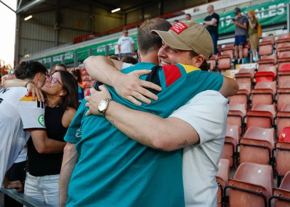 Wrexham, Wales, 8th July 2026. Christian Worns head coach of Germany embraces family and friends as he celebrates the full time result as Germany qualify for the UEFA European U19 Championship final following the Ukraine U19 vs Germany U19 UEFA European U19 Championship match at The Racecourse, Wrexham. Picture credit should read: Cody Froggatt Sportimage EDITORIAL USE ONLY. No use with unauthorised audio, video, data, fixture lists, club league logos or live services. Online in-match use limited to 120 images, no video emulation. No use in betting, games or single club league player publications. SPI_056_CF_UKRAINE_U19_V_GERMANY_U19 SPI-4857-0055