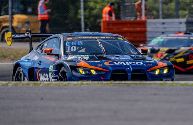 Der BMW M4 GT3 Evo 10 von FK Performance Motorsport mit VAICO-Hauptsponsor nimmt eine Kurve am Nürburgring, im Hintergrund ist ein weiteres GT3-Fahrzeug zu sehen. Das Fahrzeug trägt die dunkelblau-orange Lackierung mit gelben LED-Scheinwerfern. BMW M4 GT3 Evo 10 von FK Performance Motorsport am Nürburgring *** The BMW M4 GT3 Evo 10 from FK Performance Motorsport, with VAICO as its main sponsor, is taking a turn at the Nürburgring; with another GT3 car visible in the background. The car features a dark blue and orange paint scheme with yellow LED headlights. The BMW M4 GT3 Evo 10 from FK Performance Motorsport at the Nürburgring Copyright: xMichaelxSchäferx