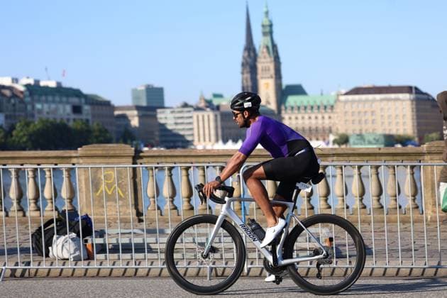 Ein Triathlet mit der Startnummer 1596 fährt auf einem weißen Radon-Rennrad am Jungfernstieg entlang der Binnenalster. Im Hintergrund ist das Hamburger Rathaus mit seinem markanten Turm zu sehen. Triathlet ( 1596) auf dem Rad am Jungfernstieg Hamburg *** A triathlete with bib number 1596 is riding a white Radon road bike along Jungfernstieg by the Binnenalster. In the background is Hamburg City Hall with its distinctive tower. Triathlete 1596 on his bike at Jungfernstieg, Hamburg Copyright: xspeedshotx xSarahxWolfx