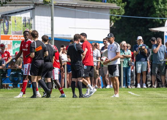 Fußball, Herren, Testspiel, Saison 2026 2027, Hallescher FC - FC Energie Cottbus in Finsterwalde, nach einer rassistischen Beleidigung ausgehend von einem Fan des HFC wurde das Spiel Mitte der zweiten Halbzeit abgebrochen, im Bild: Trainer Claus-Dieter Pele Wollitz (Energie Cottbus) bei Schiedsrichter Marcel Riemer, der die Partie abbricht, 11.07. 2026, *** Soccer, Men s, Friendly Match, 2026–2027 Season, Hallescher FC vs. FC Energie Cottbus in Finsterwalde; following a racist slur from an HFC fan, the game was called off midway through the second half. Pictured: Energie Cottbus coach Claus Dieter Pele Wollitz with referee Marcel Riemer, who called off the match, July 11, 2026, Copyright: xSebastianxRäppold MatthiasxKochx