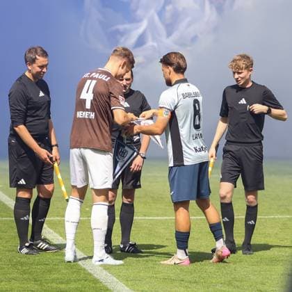 Der FC St. Pauli-Kapitän mit der Rückennummer 4 (Nemeth) und der Kapitän von SV Babelsberg 03 (Rückennummer 8, Lätn...) tauschen vor dem Schiedsrichter den Wimpel aus. Zwei Linienrichter flankieren die Gruppe auf dem Rasen in Potsdam. Wimpeltausch der Kapitäne vor dem Anpfiff im Karl-Liebknecht-Stadion *** FC St. Pauli captain Nemeth (No. 4) and SV Babelsberg 03 captain (No. 8), Lätn exchange the pennants in front of the referee. Two linesmen flank the group on the field in Potsdam. The captains exchange pennants before kickoff at Karl Liebknecht Stadium. Copyright: xAndreasxTolksdorfx