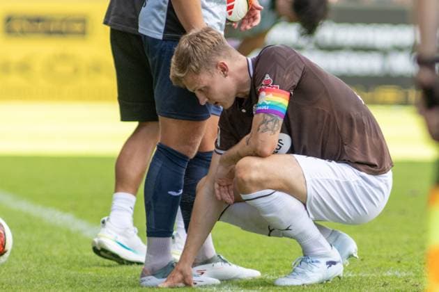 Ein Spieler des FC St. Pauli kauert mit schmerzverzerrtem Gesicht auf dem Rasen und stützt sich mit einer Hand ab, während ein Gegenspieler von SV Babelsberg 03 neben ihm steht. Am Arm trägt er eine Regenbogen-Kapitänsbinde mit dem FC St. Pauli-Schriftzug. David Nemeth kauert verletzt auf dem Rasen im Karl-Liebknecht-Stadion *** An FC St. Pauli player is crouching on the field with a pained expression on his face, supporting himself with one hand, while an opponent from SV Babelsberg 03 stands next to him. On his arm, he wears a rainbow captain’s armband with the FC St. Pauli logo. David Nemeth crouches injured on the field at Karl Liebknecht Stadium. Copyright: xspeedshotx xAndreasxTolksdorfx