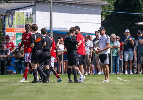 Fußball, Herren, Testspiel, Saison 2026 2027, Hallescher FC - FC Energie Cottbus in Finsterwalde, nach einer rassistischen Beleidigung ausgehend von einem Fan des HFC wurde das Spiel Mitte der zweiten Halbzeit abgebrochen, im Bild: King Manu (Energie Cottbus) und Trainer Claus-Dieter Pele Wollitz (Energie Cottbus) bei Schiedsrichter Marcel Riemer, der die Partie abbricht, 11.07. 2026, *** Soccer, Men s, Friendly Match, 2026–2027 Season, Hallescher FC vs. FC Energie Cottbus in Finsterwalde; following a racist slur directed by an HFC fan, the match was called off midway through the second half, Pictured: King Manu of Energie Cottbus and coach Claus Dieter Pele Wollitz of Energie Cottbus with referee Marcel Riemer, who called off the match, July 11, 2026, Copyright: xSebastianxRäppold MatthiasxKochx