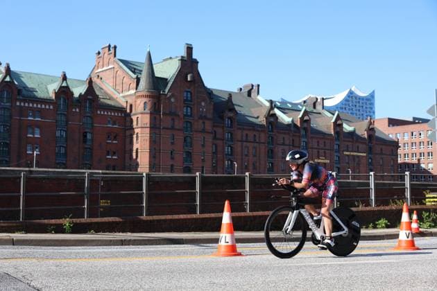 Ein Triathlet absolviert die Radstrecke des Triathlons an der Binnenalster. Im Hintergrund prägen die historischen Speicherbauten und die Elphi das Bild. Triathlet auf der Radstrecke vorbei an der Elbphilarmonie in Hamburg *** A triathlete completes the cycling leg of the triathlon along the Binnenalster. In the background, the historic warehouse buildings and the Elphi dominate the scene. A triathlete on the cycling course, passing the Elbphilharmonie in Hamburg Copyright: xspeedshotx xSarahxWolfx