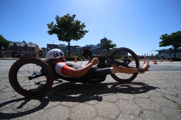 Ein Athlet auf einem Handbike absolviert eine Trainingsfahrt auf dem Jungfernstieg an der Binnenalster. Die Strecke ist mit Pylonen markiert, im Hintergrund die Hamburger Hafencity-Skyline. Handbike-Fahrer auf dem Jungfernstieg in Hamburg *** An athlete on a handbike is completing a training ride on the Jungfernstieg along the Binnenalster. The route is marked with cones; in the background is the Hamburg HafenCity skyline. Handbike riders on the Jungfernstieg in Hamburg Copyright: xspeedshotx xSarahxWolfx