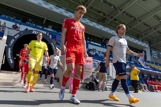 GER, Jena, Fussball, Testspiel, FC Carl-Zeiss Jena vs. 1. FC Union Berlin im Bild v.l.: Aljoscha Kemlein (1. FC Union Berlin 06), Nils Butzen (FC Carl-Zeiss Jena 26), beim Einlaufen der Teams mit Wimpel in der Hand 12.07.2026, Ernst-Abbe Sportfeld Jena DFB REGULATIONS PROHIBIT ANY USE OF PHOTOGRAPHS AS IMAGE SEQUENCES AND OR QUASI-VIDEO, *** GER, Jena, Soccer, Friendly Match, FC Carl Zeiss Jena vs. 1. FC Union Berlin; pictured from left: Aljoscha Kemlein (1. FC Union Berlin 06), Nils Butzen, FC Carl Zeiss Jena 26, as the teams enter the field holding pennants, July 12, 2026, Ernst Abbe Sportfeld, Jena. DFB regulations prohibit any use of photographs as image sequences and or quasi-video, Copyright: HMBxMedia PaulxFritz