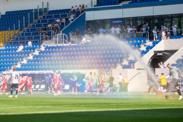 GER, Jena, Fussball, Testspiel, FC Carl-Zeiss Jena vs. 1. FC Union Berlin im Bild v.l.: Rasensprenger erzeugt Regenbogen in der Halbzeit 12.07.2026, Ernst-Abbe Sportfeld Jena DFB REGULATIONS PROHIBIT ANY USE OF PHOTOGRAPHS AS IMAGE SEQUENCES AND OR QUASI-VIDEO, *** GER, Jena, Soccer, Friendly Match, FC Carl Zeiss Jena vs. 1. FC Union Berlin (pictured, from left): A sprinkler creates a rainbow at halftime on July 12, 2026, Ernst Abbe Sportfeld, Jena. DFB regulations prohibit any use of photographs as image sequences and or quasi-video, Copyright: HMBxMedia PaulxFritz