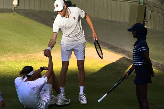 Tennis - 2026 Wimbledon Championships - Day Eleven (Week Two) - All England Lawn Tennis & Croquet Club, London - Sunday 12th July 2026 Centre Court - Mens singles Final Jannik Sinner (ITA) v Alexander Zverev (GER) Jannik Sinner helps Alexander Zverev (GER) to his feet after he sliped on the grass COLORSPORT ANDREW COWIE 