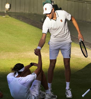Tennis - 2026 Wimbledon Championships - Day Eleven (Week Two) - All England Lawn Tennis & Croquet Club, London - Sunday 12th July 2026 Centre Court - Mens singles Final Jannik Sinner (ITA) v Alexander Zverev (GER) Jannik Sinner helps Alexander Zverev (GER) to his feet after he sliped on the grass COLORSPORT ANDREW COWIE 