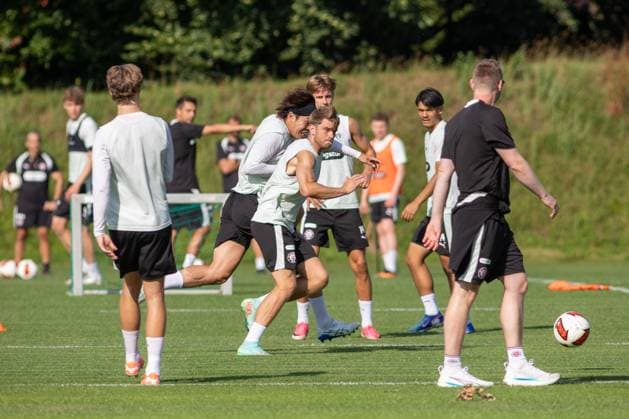 Marcus Mathisen ( 6 FC St. Pauli) und Tomoya Ando ( 15 FC St. Pauli) liefern sich einen intensiven Zweikampf auf dem Trainingsplatz. Im Hintergrund beobachten mehrere Mitspieler die Übungseinheit. Zweikampf im Training des FC St. Pauli in Hamburg *** Marcus Mathisen (No. 6, FC St. Pauli) and Tomoya Ando (No. 15, FC St. Pauli) engage in an intense one-on-one battle on the practice field. In the background, several teammates watch the drill during FC St. Pauli’s training session in Hamburg. Copyright: xAndreasxTolksdorfx