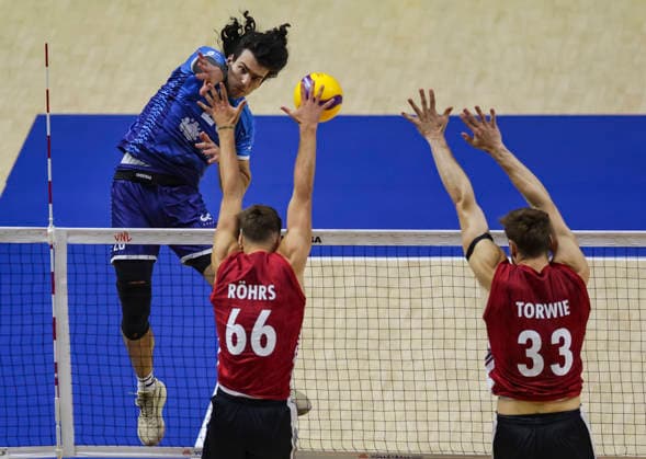 Men s Volleyball Nations League - Belgrade 2026 Slovenia s Nik Mujanovic spikes the ball against Germany s Erik Rohrs and Germany s Simon Valentin Torwie during the MenÕs Volleyball Nations League Pool 7 match between Germany and Slovenia at Belgrade Arena on July 15, 2026 in Belgrade, Serbia. Belgrade Serbia Copyright: xSrdjanxStevanovicx x