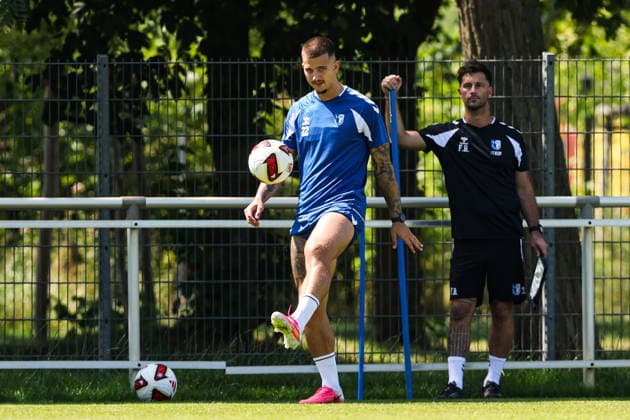 Mateusz Zukowski (1. FC Magdeburg,22) und im Hintergrund Athletiktrainer Felix Binsker (1. FC Magdeburg) - 2. Fußball Bundesliga Saison 2026-2027 Training 1. FC Magdeburg an der Avnet Arena in Magdeburg - Fußball,Mann,Männer,Deutschland,15.07.2026 *** Mateusz Zukowski, 1 FC Magdeburg, 22, with strength and conditioning coach Felix Binsker (1 FC Magdeburg) in the background; 2026–2027 Bundesliga season; 1 FC Magdeburg training session at the Avnet Arena in Magdeburg; soccer, man,Men, Germany, July 15, 2026