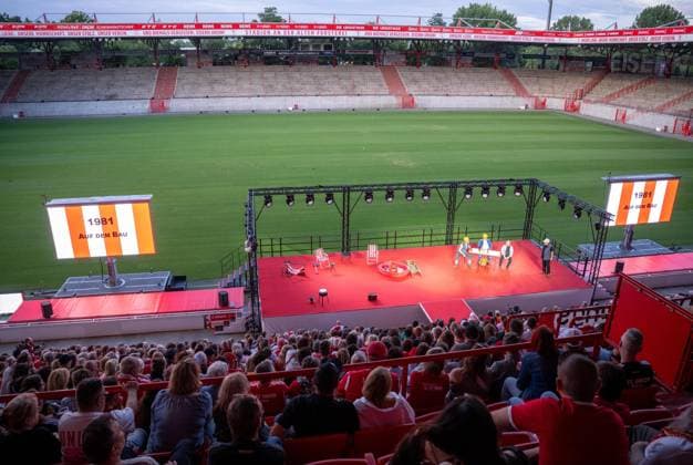 Fußball, Saison 2026 2027, 1. Bundesliga, 1. FC Union Berlin, Union-Theater, Und niemals vergessen: Eisern Union - Das Stück zum Spiel, erste Vorstellung im Stadion An der Alten Försterei, im Bild: Bühne und Zuschauer, 15.07. 2026, *** Soccer, 2026–2027 season, Bundesliga 1, 1. FC Union Berlin, Union Theater, And Never Forget: Eisern Union —the play based on the game, first performance at the An der Alten Försterei stadium; pictured: the stage and the audience, July 15, 2026, Copyright: xMatthiasxKochx