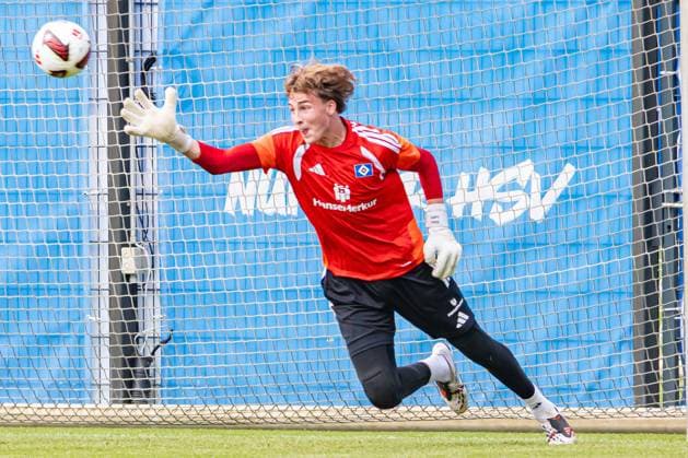 Ein Torwart des Hamburger SV wirft sich mit ausgestrecktem Arm dem Ball entgegen und versucht eine Parade. Im Hintergrund ist das HSV-Logo auf einer blauen Werbebande zu sehen. Fernando Dickes ( 41; Hamburger SV) streckt sich nach dem Ball im Training *** A Hamburg SV goalkeeper dives toward the ball with his arm outstretched, trying to make a save. In the background, the HSV logo can be seen on a blue advertising banner. Fernando Dickes 41: Hamburg SV reaches for the ball during practice Copyright: xAndreasxTolksdorfx