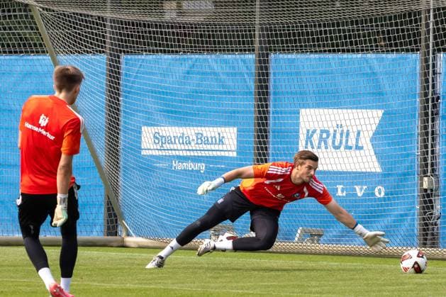 Ein Torwart des Hamburger SV hecht?? im Training zur Seite und versucht den Ball mit ausgestrecktem Arm zu erreichen. Im Hintergrund steht ein weiterer Torwart vor dem Tor. HSV-Torwart bei Parade im Training am Volksparkstadion *** A goalkeeper for Hamburger SV dives to the side during practice, trying to reach the ball with his arm outstretched. In the background, another goalkeeper stands in front of the goal. HSV goalkeeper making a save during practice at the Volksparkstadion Copyright: xspeedshotx xAndreasxTolksdorfx