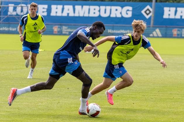 Drei Hamburger SV-Spieler in einer intensiven Trainingseinheit auf dem Trainingsgelände am Volksparkstadion. Zwei Spieler kämpfen im Zweikampf um den Ball, ein dritter läuft im Hintergrund heran. HSV-Spieler im Zweikampf beim Training am Volksparkstadion *** Three Hamburger SV players during an intense training session at the training facility at the Volksparkstadion. Two players are battling for the ball, while a third runs up in the background. HSV players in a tackle during training at the Volksparkstadion Copyright: xspeedshotx xAndreasxTolksdorfx