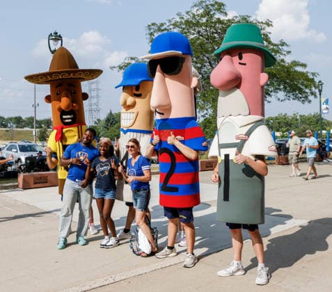 Fans pose with the racing sausages as smoke from Canadian wildfires hangs over American Family Field before the start of the baseball game between the Miami Marlins and the Milwaukee Brewers in Milwaukee, Wisconsin on Friday July 17, 2026. Hundreds of wildfires have sent smoke and particulate matter into much of the north and northeastern US.  MIL20260717801 TANNENxMAURY