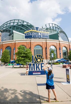 Fans pose for pictures as smoke from Canadian wildfires hangs over American Family Field before the start of the baseball game between the Miami Marlins and the Milwaukee Brewers in Milwaukee, Wisconsin on Friday July 17, 2026. Hundreds of wildfires have sent smoke and particulate matter into much of the north and northeastern US.  MIL20260717805 TANNENxMAURY