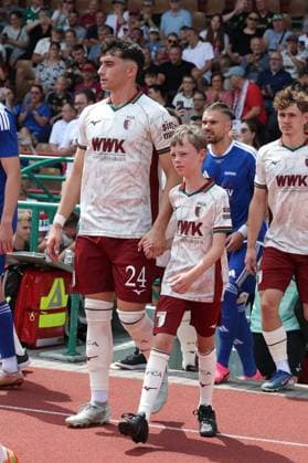 Thomas Kastanaras 24 (FC Augsburg) mit einem Einlaufkind an der Hand, FC Augsburg vs. BFV-Schwaben-Auswahl, Fussball, 1. Bundesliga, Testspiel, Saison 2026 27, 18.07.2026 Augsburg Bayern Deutschland *** Thomas Kastanaras, 24, of FC Augsburg, holding the hand of a child leading the players onto the field; FC Augsburg vs. BFV Schwaben All-Stars; soccer; Bundesliga 1; friendly match; 2026–27 season; July 18, 2026; Augsburg, Bavaria, Germany Copyright: xkolbert-press ChristianxKolbertx