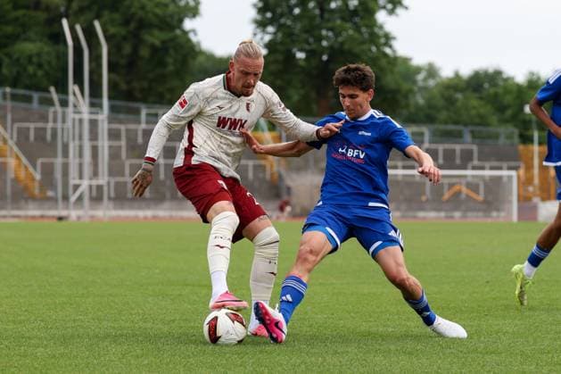 im Zweikampf, Aktion, mit Marius Wolf 27 (FC Augsburg), Finn Schmutterer 19 (TSV Bobingen), FC Augsburg vs. BFV-Schwaben-Auswahl, Fussball, 1. Bundesliga, Testspiel, Saison 2026 27, 18.07.2026 Augsburg Bayern Deutschland *** One-on-one, action, featuring Marius Wolf 27 (FC Augsburg) and Finn Schmutterer 19 (TSV Bobingen), FC Augsburg vs. BFV Schwaben Select, soccer, 1. Bundesliga, Friendly, 2026–27 season, July 18, 2026, Augsburg, Bavaria, Germany Copyright: xkolbert-press ChristianxKolbertx