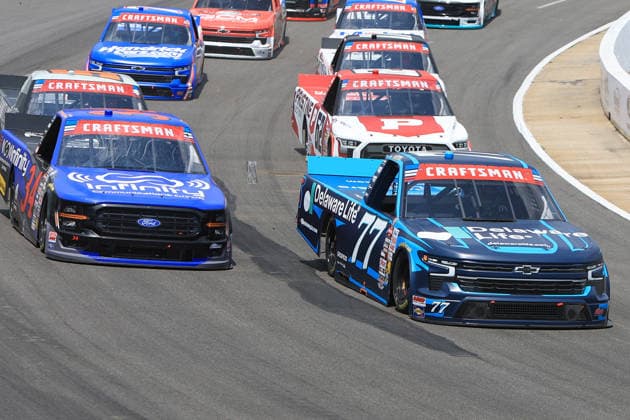 NORTH WILKESBORO, NC - JULY 18: Carson Hocevar ( 77 Spire Motorsports Delaware Life Chevrolet) races Layne Riggs ( 34 Front Row Motorsports Infinite Communications Group Ford) into turn 1 during the running of the NASCAR, Motorsport, USA Craftsman Truck Series FaithFest 250 on July 18, 2026 at North Wilkesboro Speedway in North Wilkesboro, NC. (Photo by Jeff Robinson Icon Sportswire) AUTO: JUL 18 NASCAR CRAFTSMAN Truck Series Faith Fest 250 EDITORIAL USE ONLY Icon26071824594250
