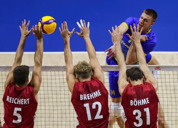 WomenÕs Volleyball Nations League - Belgrade 2026 Ukraine s Illa Kovalov spikes the ball against Germany s Moritz Reichert (L) Germany s Anton Brehme and Germany s Yann Bohme during the MenÕs Volleyball Nations League Pool 7 match between Germany and Ukraine at Belgrade Arena on July 19, 2026 in Belgrade, Serbia. Belgrade Serbia Copyright: xSrdjanxStevanovicx x