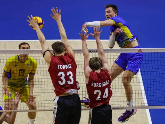 WomenÕs Volleyball Nations League - Belgrade 2026 Ukraine s Oleh Plotnytskyi spikes the ball against Germany s Simon Valentin Torwie and Germany s Eric Burggraf during the MenÕs Volleyball Nations League Pool 7 match between Germany and Ukraine at Belgrade Arena on July 19, 2026 in Belgrade, Serbia. Belgrade Serbia Copyright: xSrdjanxStevanovicx x