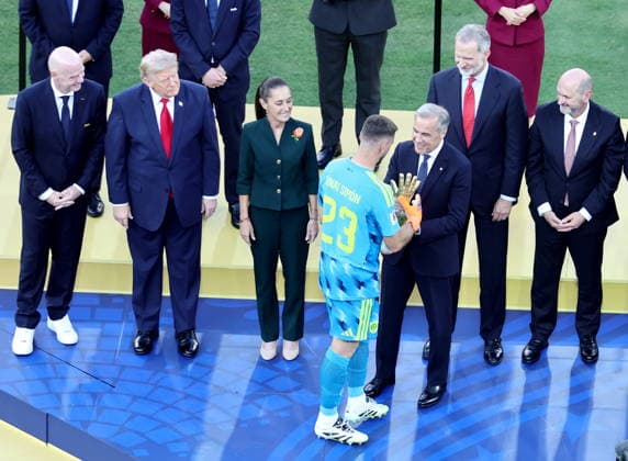 FIFA World Cup, WM, Weltmeisterschaft, Fussball 2026 final - Spain vs Argentina Canadian Prime Minister Mark Carney hands goalkeeper Unai Simon of Spain the Golden Glove as best goalkeeper of the tournament as (from L) FIFA president Gianni Infantino, US President Donald J. Trump, Mexican President Claudia Sheinbaum and King Felipe VI of Spain look on during the victory ceremony after the FIFA World Cup 2026 final match Spain against Argentina, in New Jersey, USA, 19 July 2026. Spain won 1-0. EAST RUTHERFORD United States  Copyright: xRONALDxWITTEKx