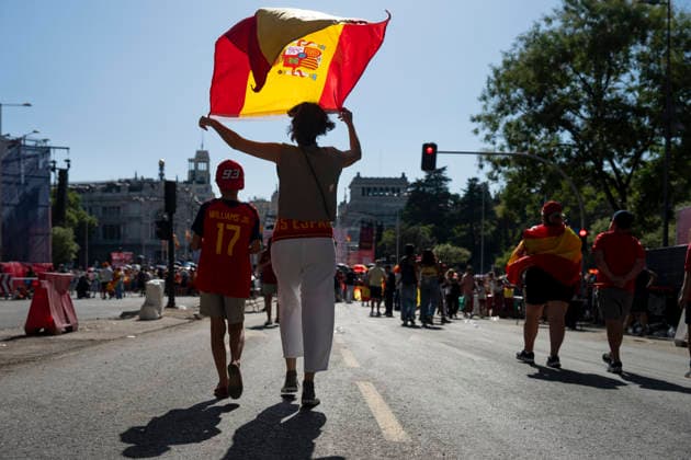 Spanish national team, Nationalteam s victory parade in Madrid - 20 Jul 2026 A Spanish football fan holds a national flag high over her head while walking down an avenue toward Plaza de Cibeles during the World Cup victory parade. An estimated two million people flooded the capital s streets to welcome the squad following their 1-0 win against Argentina in the 2026 FIFA World Cup, WM, Weltmeisterschaft, Fussball final. Madrid Spain Copyright: xMiguelxCandelax xSOPAxImagesx MC_WCWinnerParade9104
