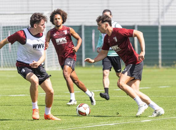 Thomas Kastanaras (FC Augsburg 24) im Zweikampf gegen Tim Schnitzer (li.), Han-Noah Massengo (FC Augsburg 4, Mitte, hinten); FC Augsburg, Training, *** Thomas Kastanaras (FC Augsburg 24) in a one-on-one with Tim Schnitzer (left), Han Noah Massengo (FC Augsburg 4), center, FC Augsburg players in the background, practice,