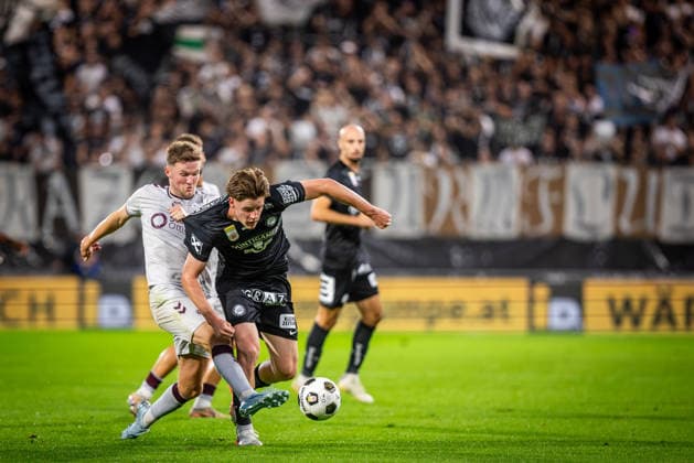 STURM GRAZ - HEARTS Simon Seidl of Sturm and Blair Spittal of Hearts during the first leg of second qualifying round of UEFA Champions League football match between Sturm Graz and Heart of Midlothian FC at the Merkur Arena (Stadion Graz Liebenau). Graz, Austria, July 21, 2026. Photo by Branislav Racko Copyright: xx 080A1745