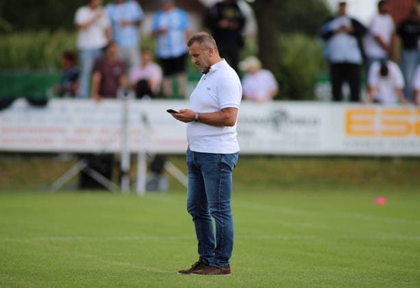Fussball, Herren, Saison 2026 2027, SV Eintracht Berglern - TSV 1860 München, Toto-Pokal Manfred Paula, Geschäftsführer (TSV 1860 München) stehend auf dem Spielfeld mit Blick auf sein Handy, Smartphone *** Soccer, Men s, 2026–2027 Season, SV Eintracht Berglern vs. TSV 1860 Munich, Toto Cup; Manfred Paula, Managing Director of TSV 1860 Munich, standing on the field looking at his cell phone, smartphone