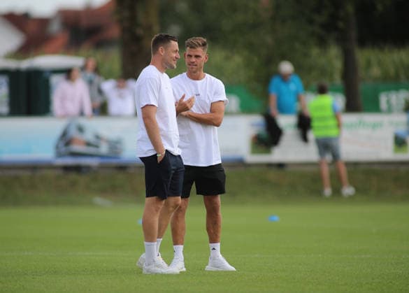 Fussball, Herren, Saison 2026 2027, SV Eintracht Berglern - TSV 1860 München, Toto-Pokal Vitus Eicher (TSV 1860 München) (li.) mit Florian Niederlechner (TSV 1860 München) zusammen stehend im Gespräch *** Soccer, Men s, 2026–2027 Season, SV Eintracht Berglern vs. TSV 1860 Munich, Toto Cup: Vitus Eicher (TSV 1860 Munich, left) and Florian Niederlechner (TSV 1860 Munich) standing together in conversation