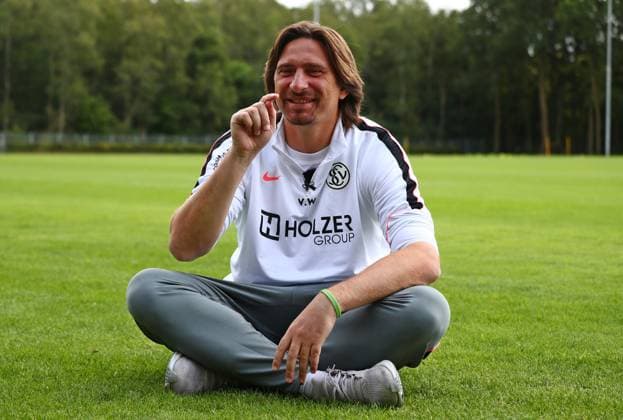 23.07.2026, NED, Fußball, Herren, 1. Bundesliga, Saison 2026 2027, Trainingslager, Rasenplatz, SV Elversberg Vincent Wagner ( Cheftrainer SV Elversberg ) beim Interview mit dem SR Saarländischen Rundfunk, er stellte eine Holzbank weg und setzte sich direkt auf den Rasen, weil das besser findet und es seine Bodenständigkeit und Herzlichkeit besser ausdrückt Stroe Rasenplatz Gelderland Niederlande *** July 23, 2026, NED, Soccer, Men s, 1. Bundesliga, 2026–2027 Season, Training camp, grass field, SV Elversberg Vincent Wagner, head coach of SV Elversberg, during an interview with SR Saarländischer Rundfunk; he moved a wooden bench aside and sat directly on the grass because he thinks it’s better and better expresses his down-to-earth nature and warmth Stroe, grass field, Gelderland, Netherlands Copyright: xNordphotox xSMx