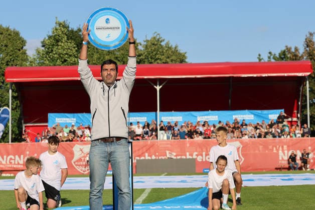 Oscar Cuquejo, Teamleiter Scouting Nachwuchs und Top-Talente vom amtierenden Titelträger 1. FC Nürnberg II brachte die offizielle Meisterschale.; Eröffnungsspiel des Bayerischen Fußball-Verbandes (BFV), Eröffnungsfeier, Fußball, Regionalliga Bayern, TSV Aubstadt - 1. FC Schweinfurt 05 5:1, 23.07.2026, NGN-Arena Aubstadt *** Oscar Cuquejo, head of youth and top talent scouting for reigning champions 1 FC Nürnberg II, brought the official championship trophy to the Bavarian Soccer Association (BFV) opening match, opening ceremony, soccer, Bavarian Regional League, TSV Aubstadt 1–05 1 FC Schweinfurt, July 23, 2026, NGN Arena Aubstadt