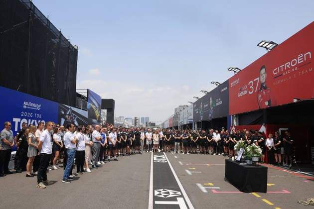 Mitglieder der FE Oragnistation sowie verschiedener Teams stehen um den Tisch mit dem Bild, Kerzen und Blumen in Gedenken an den kürzlich verstorbenen Cyril Blais (FRA) Teamchef vor der Citreon Box in der Boxengasse, FIA Formel E Weltmeisterschaft, Saison 12, Tokio E- Prix, 24.07.2026 *** Members of the FE organization and various teams stand around a table with a photo, candles, and flowers in memory of the recently deceased Cyril Blais, FRA team principal, in front of the Citroën pit in the pit lane, FIA Formula E World Championship, Season 12, Tokyo E-Prix, July 24, 2026