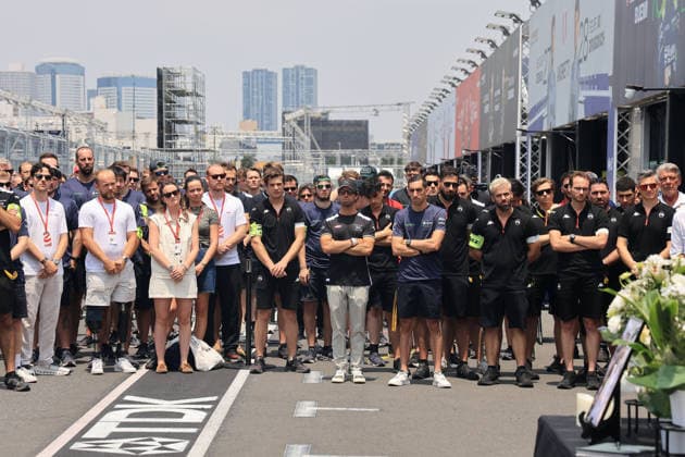 TV Leute, Fahrer und Mitglieder verschiedener Teams stehen um den Tisch mit dem Bild, Kerzen und Blumen in Gedenken an den kürzlich verstorbenen Cyril Blais (FRA) Teamchef vor der Citreon Box in der Boxengasse, FIA Formel E Weltmeisterschaft, Saison 12, Tokio E- Prix, 24.07.2026 *** TV crew, drivers, and members of various teams are standing around a table with a photo, candles, and flowers in memory of the recently deceased Cyril Blais, FRA team principal, in front of the Citroën pit in the pit lane, FIA Formula E World Championship, Season 12, Tokyo E-Prix, July 24, 2026