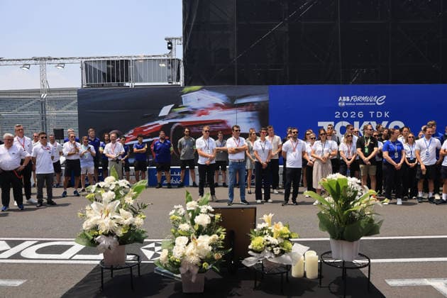 Mitglieder der FIA und FE Oragnistation sowie verschiedener Teams stehen um den Tisch mit dem Bild, Kerzen und Blumen in Gedenken an den kürzlich verstorbenen Cyril Blais (FRA) Teamchef vor der Citreon Box in der Boxengasse, FIA Formel E Weltmeisterschaft, Saison 12, Tokio E- Prix, 24.07.2026 *** Members of the FIA and FE organization, as well as various teams, stand around a table with a photo, candles, and flowers in memory of the recently deceased Cyril Blais, FRA team principal, in front of the Citroën pit in the pit lane, FIA Formula E World Championship, Season 12, Tokyo E-Prix, July 24, 2026