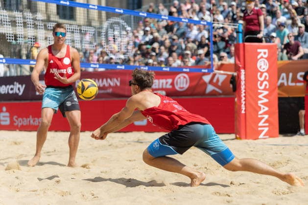 Deutsche Meisterschaften im Beach-Volleyball. 2026 Daniel Kirchner (Beachvolley United München). Links im Hintergrund Jonas Kaminski. Deutsche Meisterschaften im Beach-Volleyball am 24. Juli 2026 in Hannover. Viertelfinalspiel der Männer zwischen dem 1. Beachclub Kiel und Beachvolley United München., Hannover Niedersachsen Deutschland Opernplatz *** 2026 German Beach Volleyball Championships: Daniel Kirchner of Beachvolley United Munich; Jonas Kaminski in the background on the left. German Beach Volleyball Championships on July 24, 2026, in Hanover. Men’s quarterfinal match between 1 Beachclub Kiel and Beachvolley United Munich, Hanover, Lower Saxony, Germany, Opernplatz.