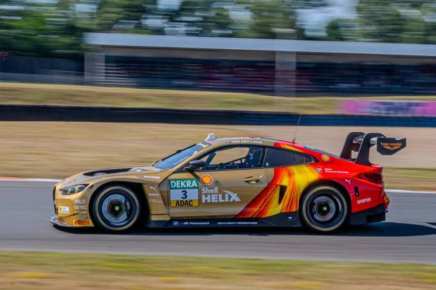 Der BMW M4 GT3 3 von Schubert Motorsport mit Kelvin van der Linde am Steuer durchfährt die Motorsport Arena Oschersleben in voller Fahrt. Die gold-rot-orange Shell-Helix-Lackierung mit flammenartiger Grafik ist auf der Fahrzeugseite deutlich zu erkennen. BMW M4 GT3 3 von Kelvin van der Linde (Schubert Motorsport) in Oschersleben *** The Schubert Motorsport BMW M4 GT3 3, with Kelvin van der Linde at the wheel, speeds through the Motorsport Arena Oschersleben. The gold, red, and orange Shell Helix livery with flame-like graphics is clearly visible on the side of the car. BMW M4 GT3 3 driven by Kelvin van der Linde, Schubert Motorsport in Oschersleben Copyright: xMichaelxSchäferx
