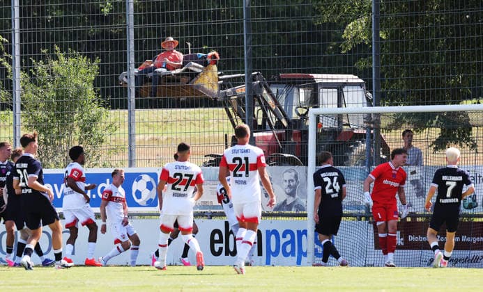 25.07.2026, Deutschland, Hollenbach, Fußball Bundesliga, Saison 2026 2027, Testspiel, Freundschaftsspiel, JAKO-Testspiel, FSV Hollenbach vs. VfB Stuttgart, Feature, Bauer schaut von der Schaufel seines Traktor das Spiel an, Tor VfB *** July 25, 2026, Germany, Hollenbach, Bundesliga, 2026–2027 season, exhibition match, friendly match, JAKO exhibition match, FSV Hollenbach vs. VfB Stuttgart, feature, farmer watches the game from the front end of his tractor, VfB goal