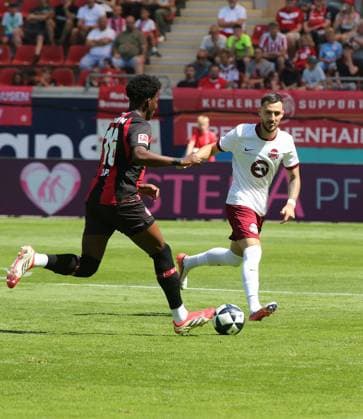25.07.2026 xmgoodx Offenbach am Main, Plutos Stadion am Bieberer Berg - Jubiläumsspiel Kickers Offenbach (OFC) - Bayer 04 Leverkusen. Axel Tape (16, Leverkusen) gegen Maximilian Wolfram (8, OFC) *** July 25, 2026 xmgoodx Offenbach am Main, Pluto Stadium at Bieberer Berg Anniversary Match: Kickers Offenbach vs. OFC Bayer 04 Leverkusen Axel Tape (16, Leverkusen) vs. Maximilian Wolfram (8, OFC)