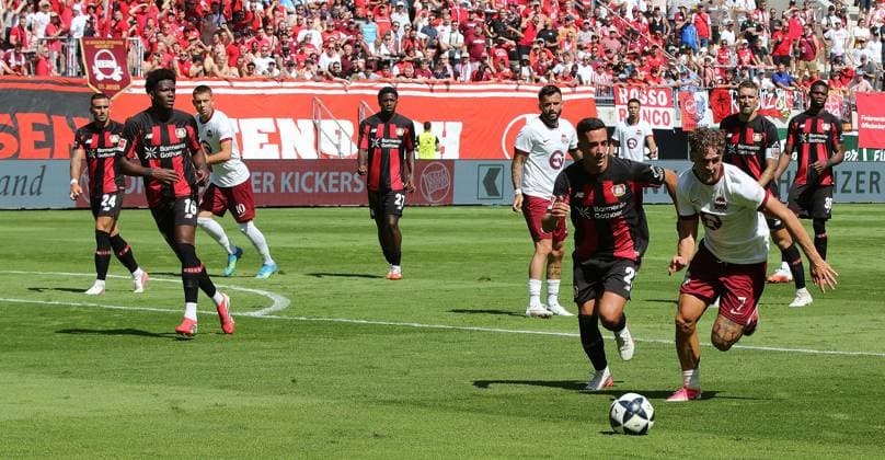 25.07.2026 xmgoodx Offenbach am Main, Plutos Stadion am Bieberer Berg - Jubiläumsspiel Kickers Offenbach (OFC) - Bayer 04 Leverkusen. Vazquez Lucas (Leverkusen) egen Luka Garic (7, OFC) *** July 25, 2026 xmgoodx Offenbach am Main, Pluto Stadium at Bieberer Berg Anniversary Match: Kickers Offenbach vs. OFC Bayer 04 Leverkusen Lucas Vazquez (Leverkusen) vs. Luka Garic 7, OFC