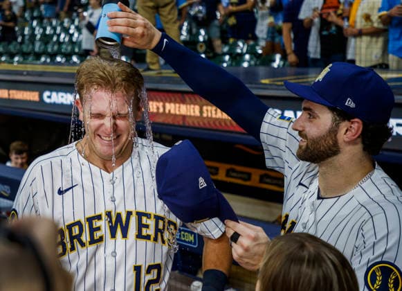 Milwaukee Brewers shortstop Cooper Pratt gets a cup of water poured on his head by Milwaukee Brewers center fielder Garrett Mitchell for hitting his second career home run in the MLB, Baseball Herren, USA game between the Colorado Rockies and the Milwaukee Brewers at American Family Field in Milwaukee, Wisconsin on Saturday July 25, 2026. The Brewers defeated the Rockies 8-5.  MIL20260725831 TANNENxMAURY